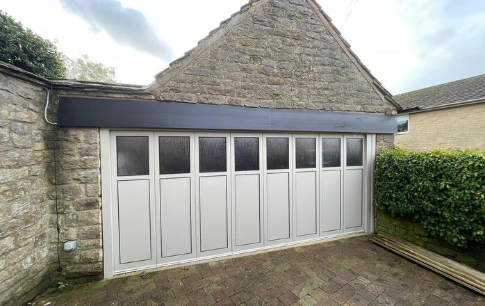 Carriage-style garage door on a stone detached garage