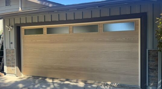 Insulated wood-look garage door with window row