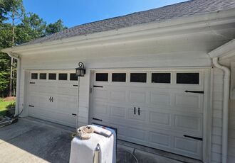 White carriage-style doors on a neighboring garage