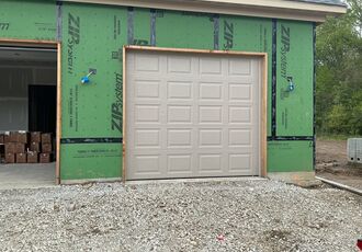 Single raised-panel garage door on new construction