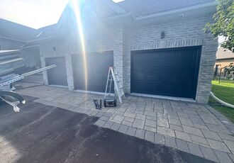 Finished black garage doors on stone home